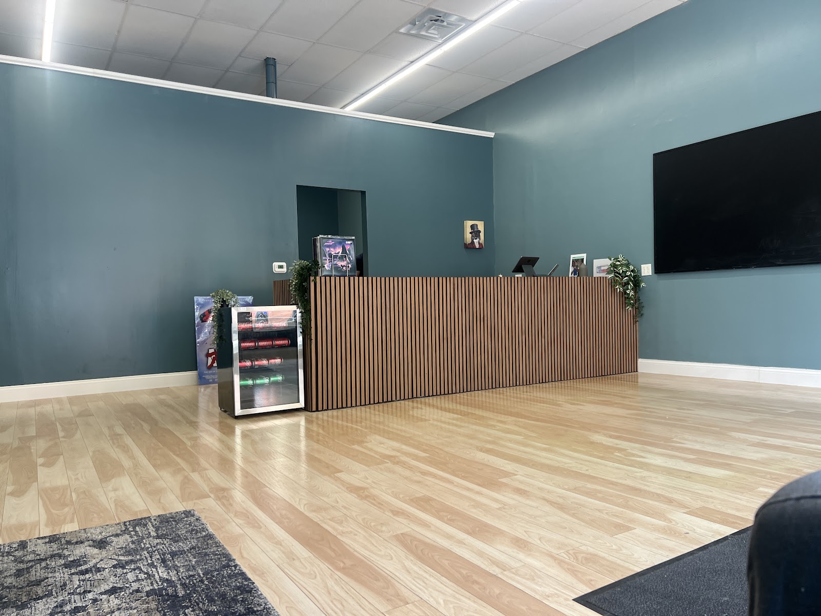 Shop interior: teal walls, wide wooden slatted counter, hardwood floors